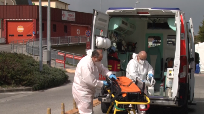 Igienizzazione di un'ambulanza dopo un servizio all'ospedale Lotti, dietro il mezzo c'è il pronto soccorso